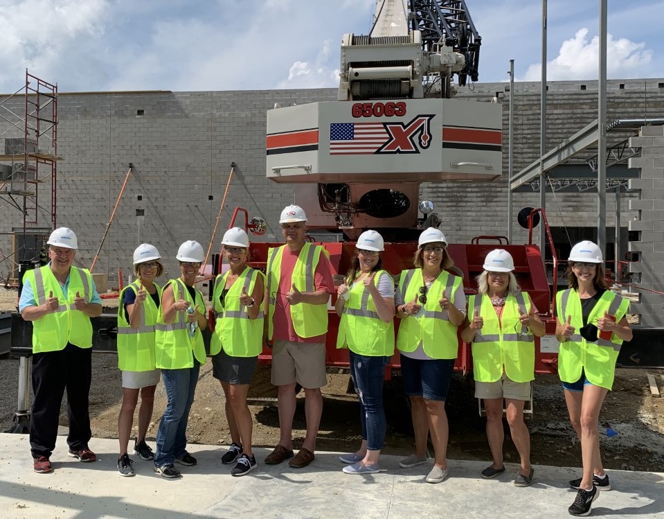 people wearing green construction vests on a construction site